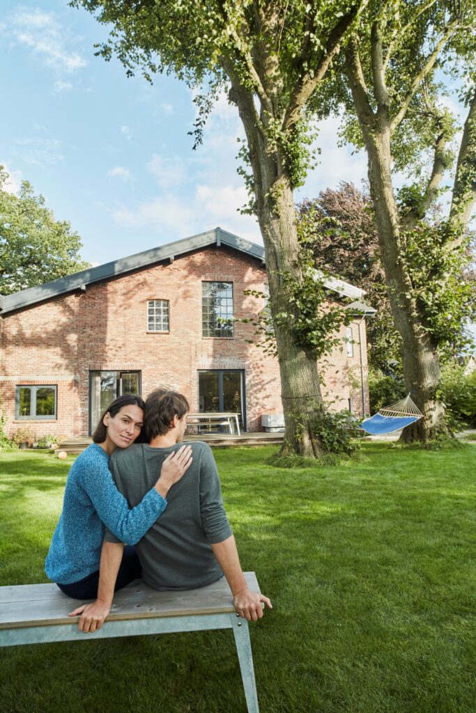 Couple profitant de leur jardin en été grâce à une maison bien isolée avant l'été