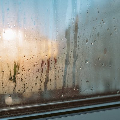 Condensation forming on double glazed window. Contrast cold air and humidity. Drops on glass. Cold room. Backlight poor glass sealing
