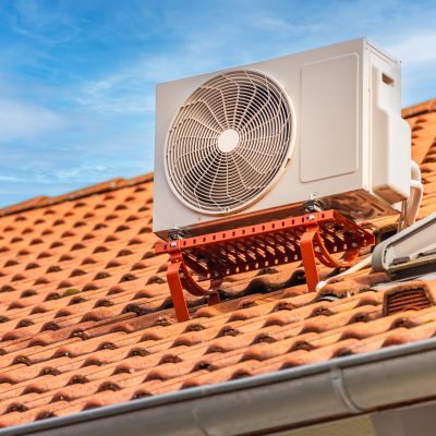 Dual inverter compressor, combination of air conditioner compressor and heating pump, installed on a roof of family house.